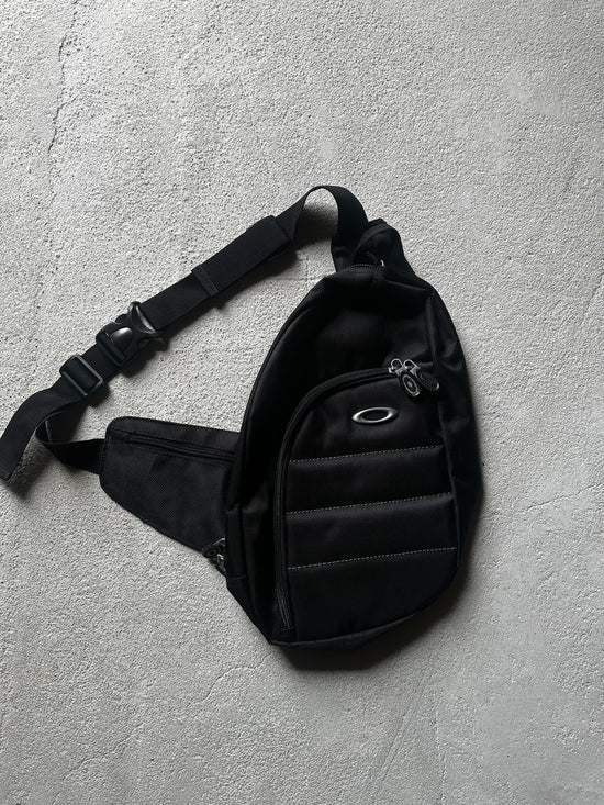 Retro crossbody-väska från Oakley med sportig form och teknisk design