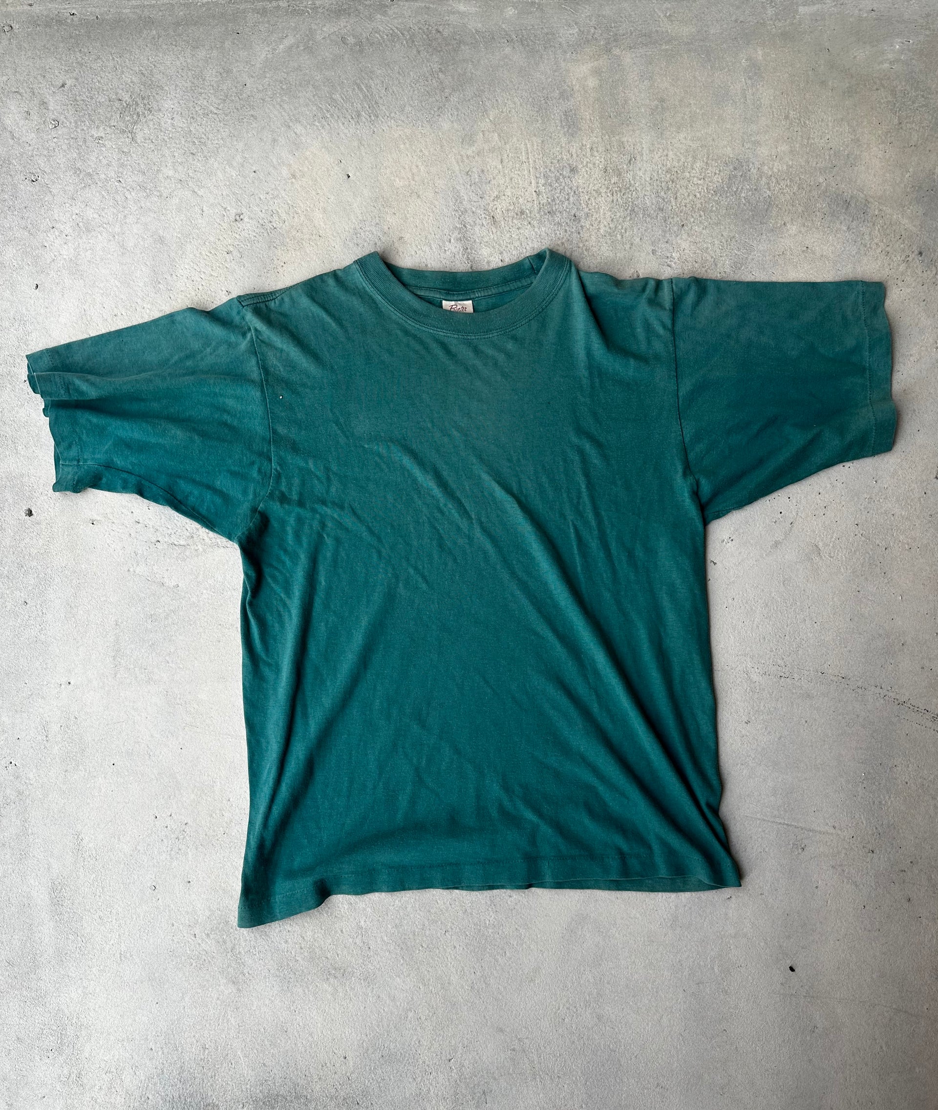 Vintage plain green single stitch T-shirt with faded cotton fabric.