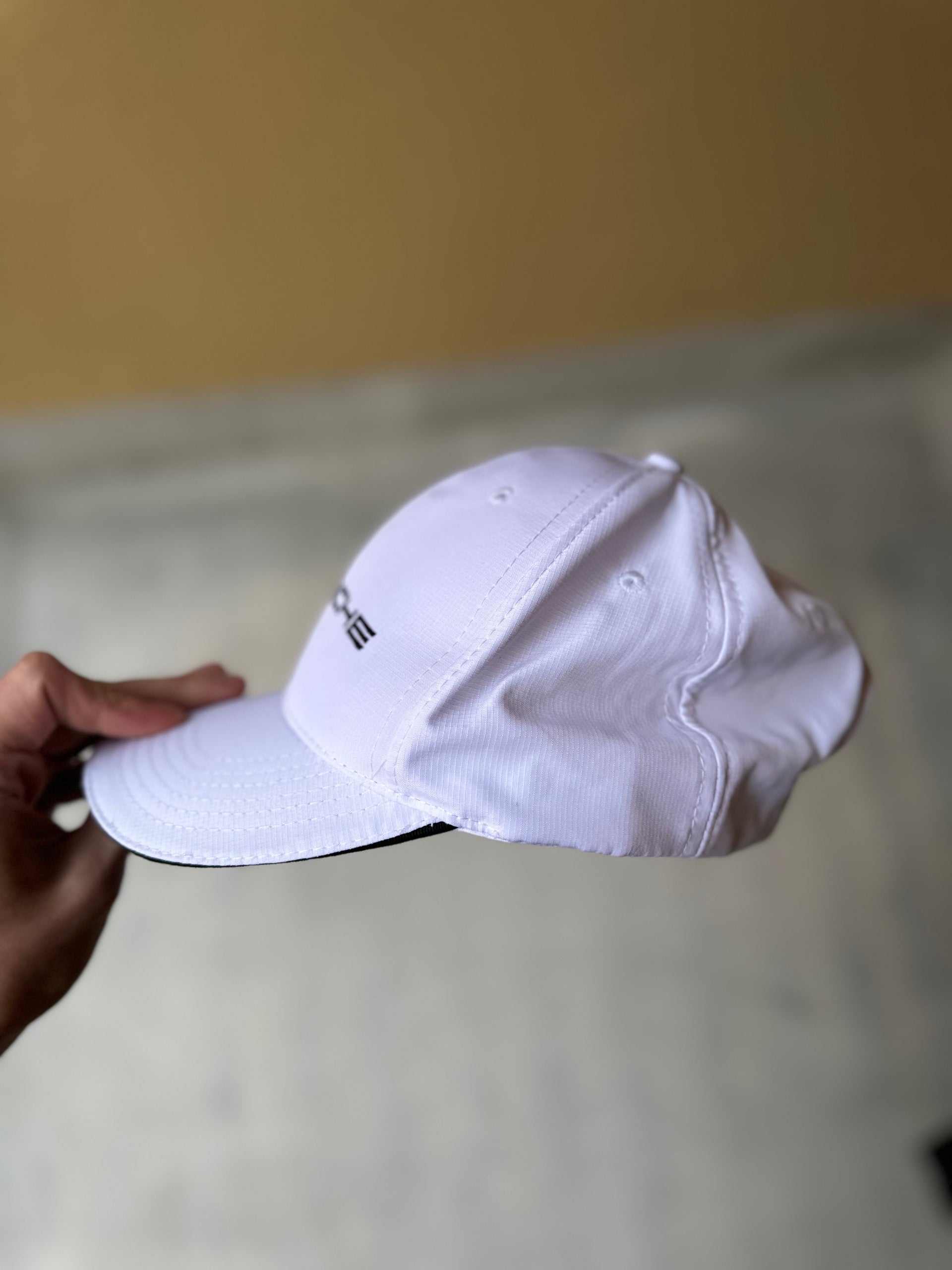 White Porsche hat with a modern and clean design, photographed from above.