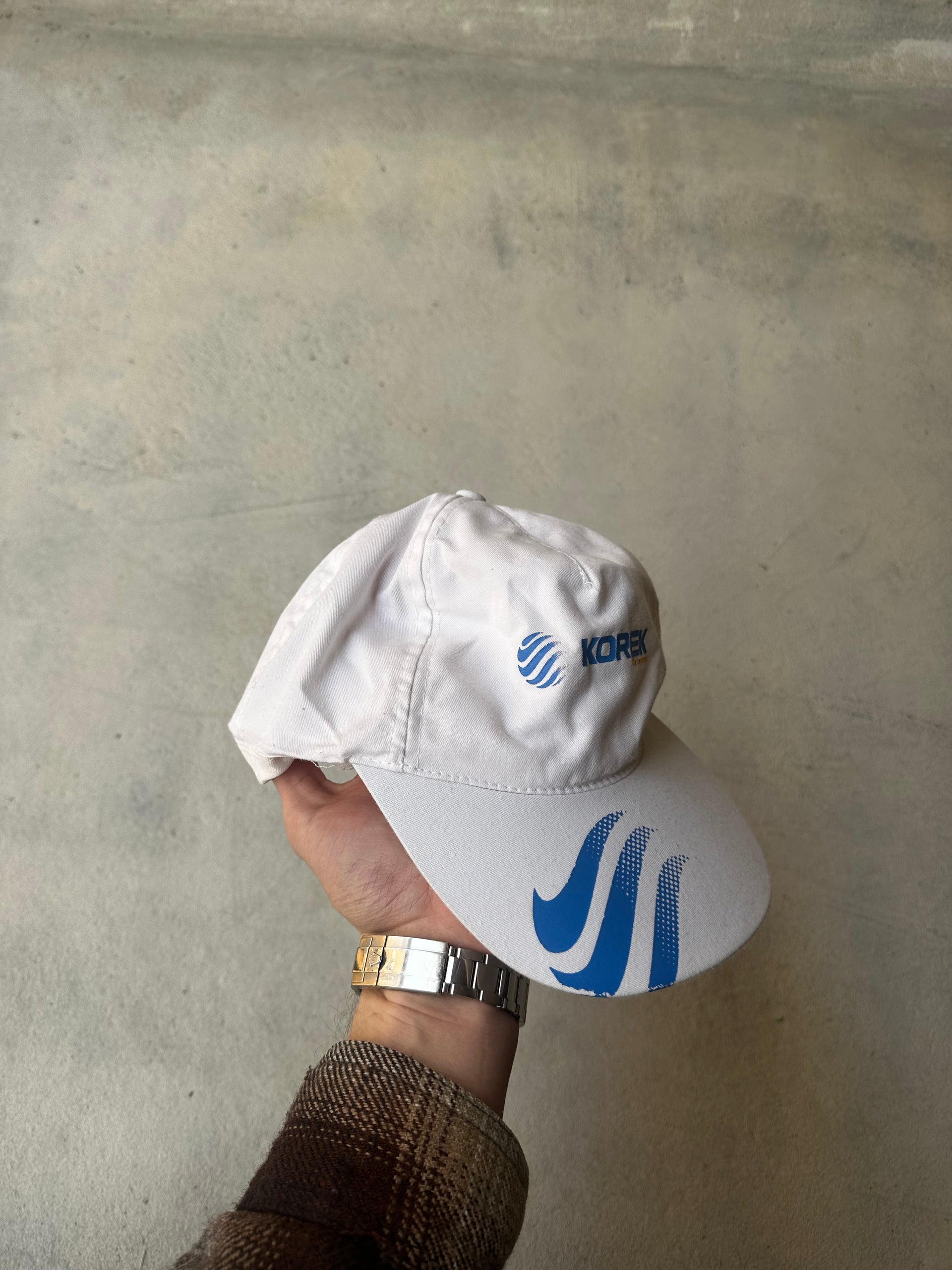 Classic adjustable Korek hat with blue graphic details on the visor.