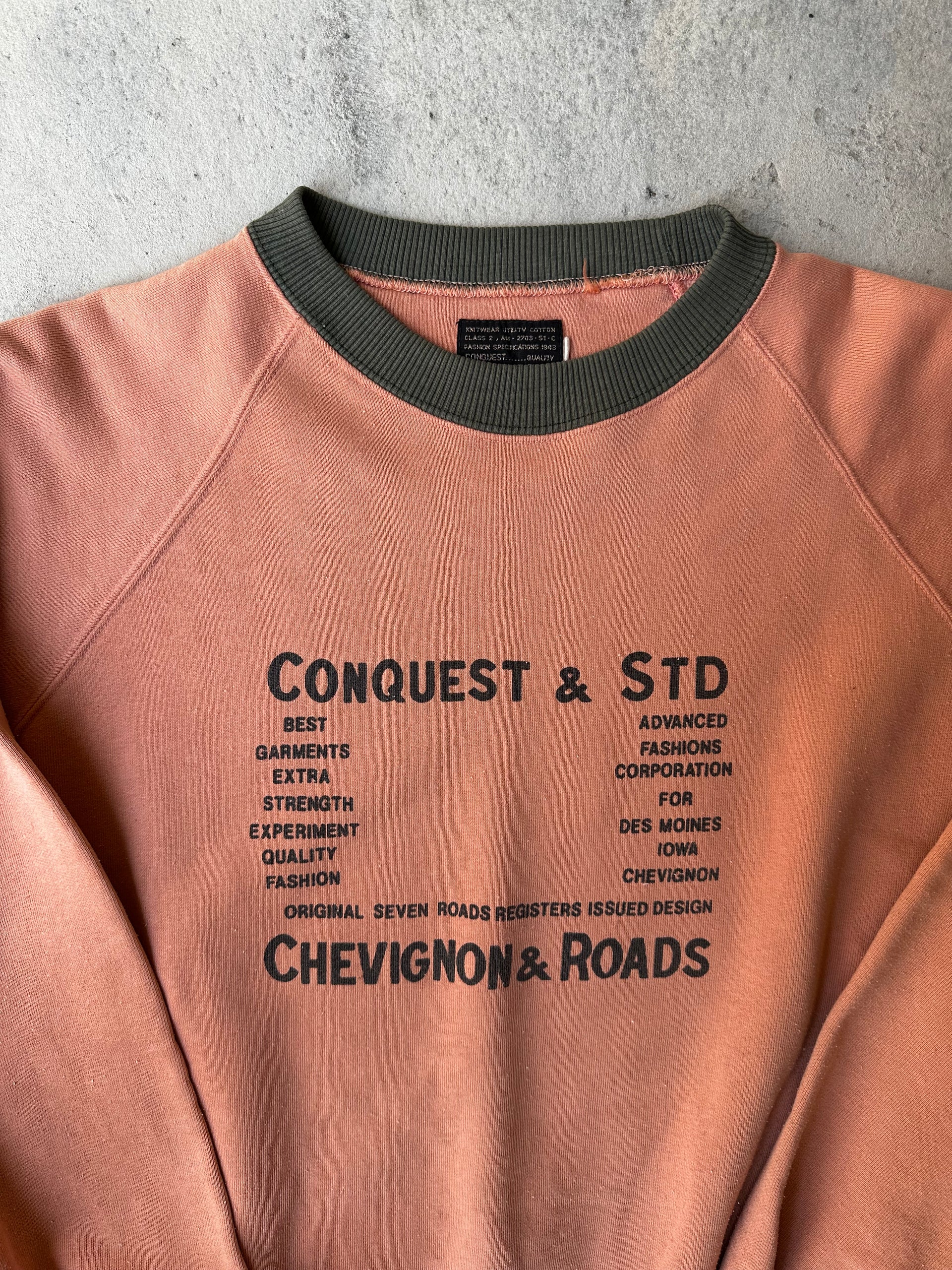 Close-up of faded text graphic on vintage Chevignon & Roads sweatshirt.