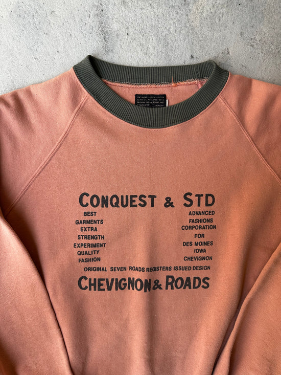 Close-up of faded text graphic on vintage Chevignon & Roads sweatshirt.
