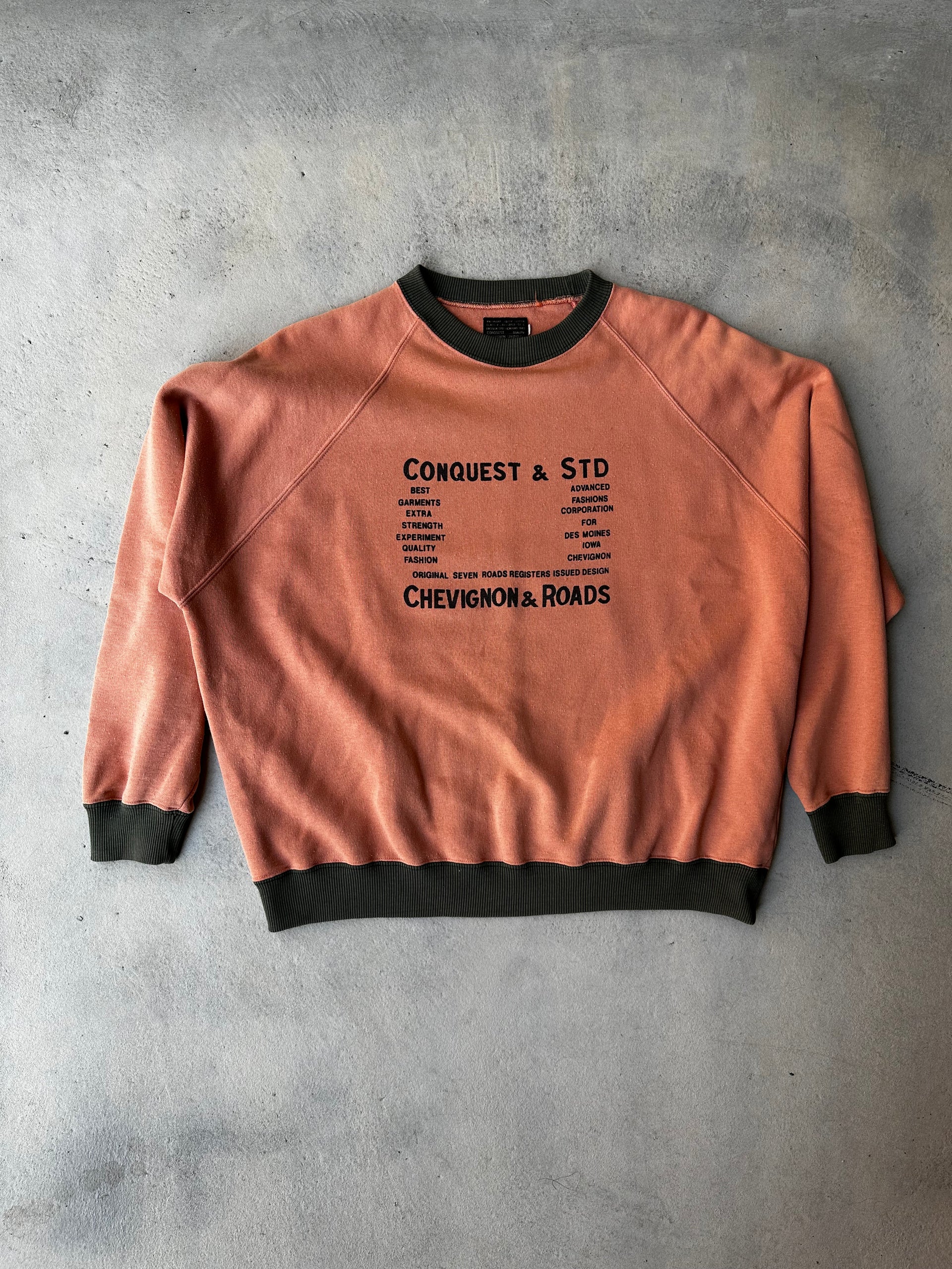 Laid-flat burnt orange Chevignon sweatshirt with black ribbed trim and worn-in feel
