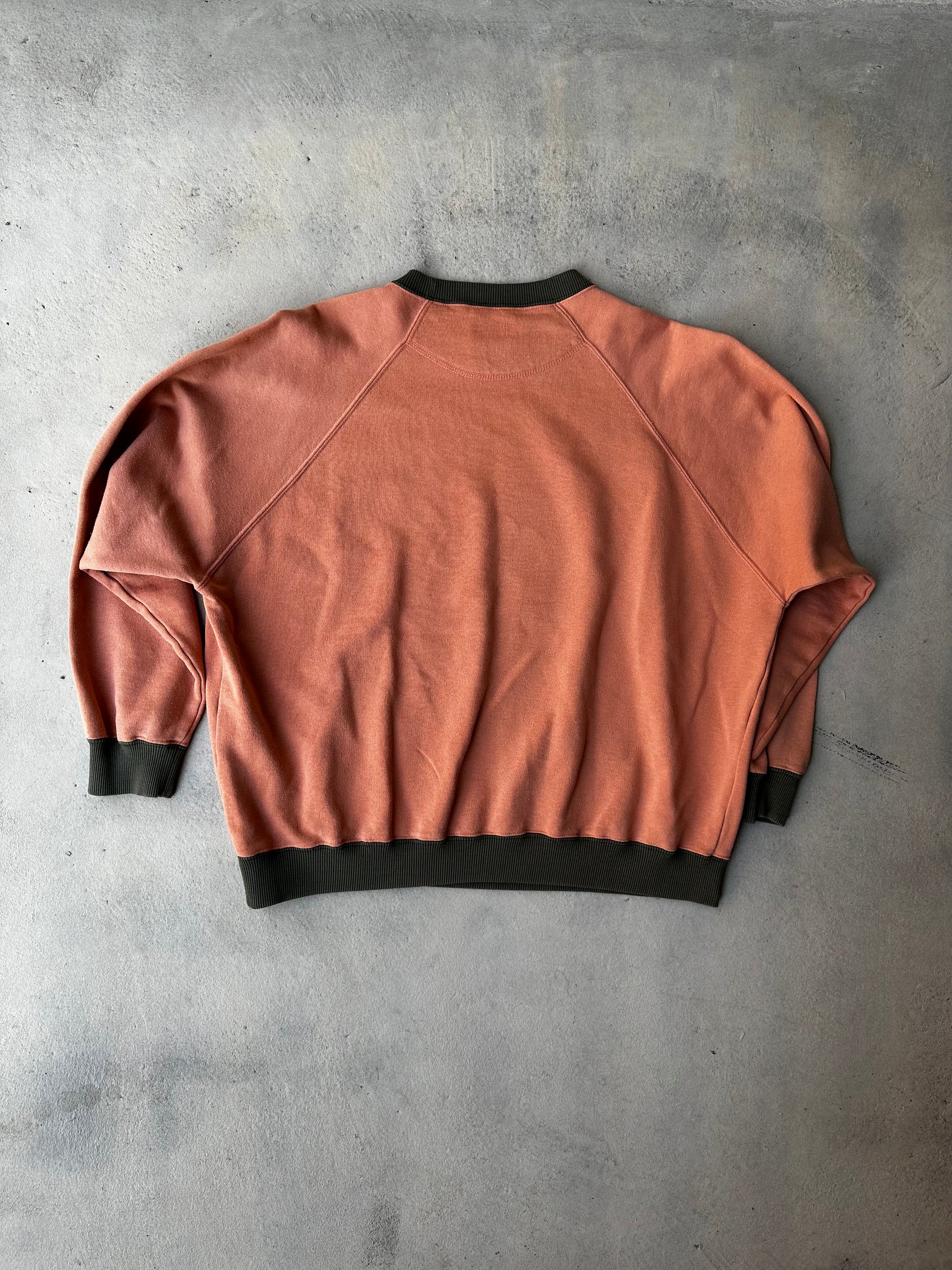 Laid-flat burnt orange Chevignon sweatshirt with black ribbed trim and worn-in feel. Showing the back.