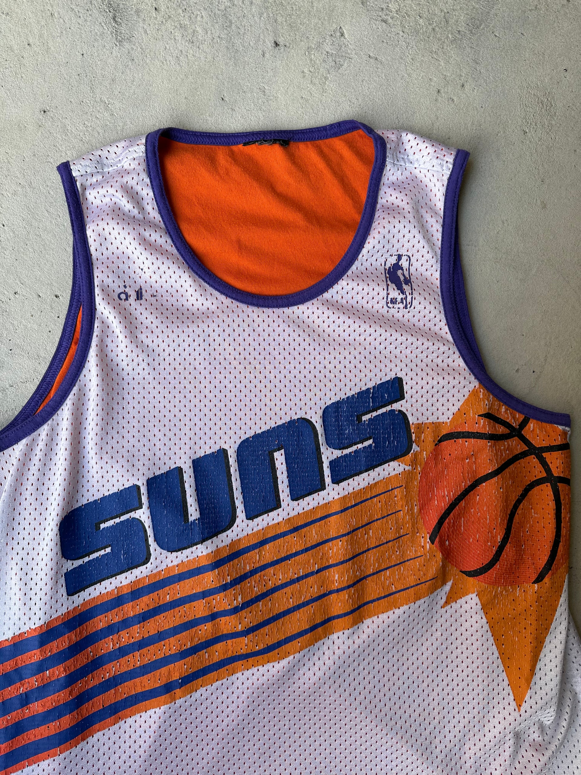 Close-up of Phoenix Suns graphic on vintage 90s basketball jersey.