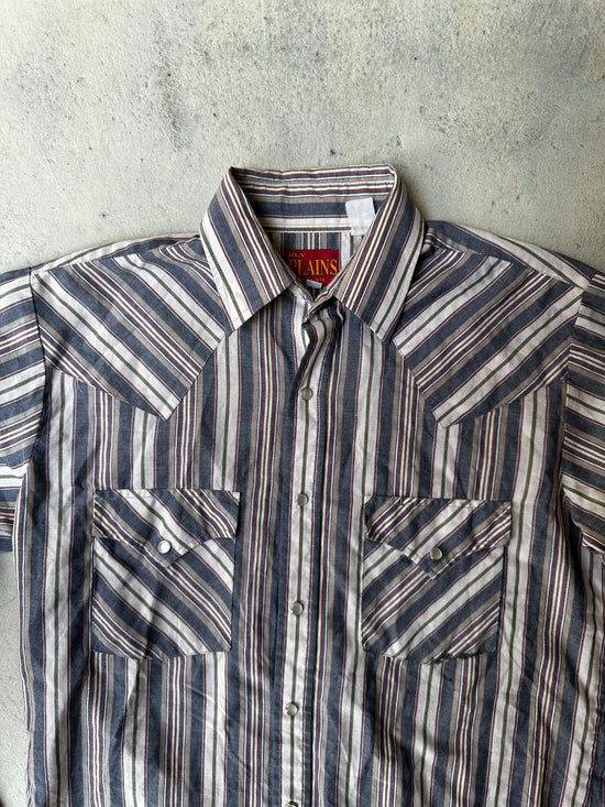 Close-up of striped western shirt featuring pearl snap buttons and contrast stitching