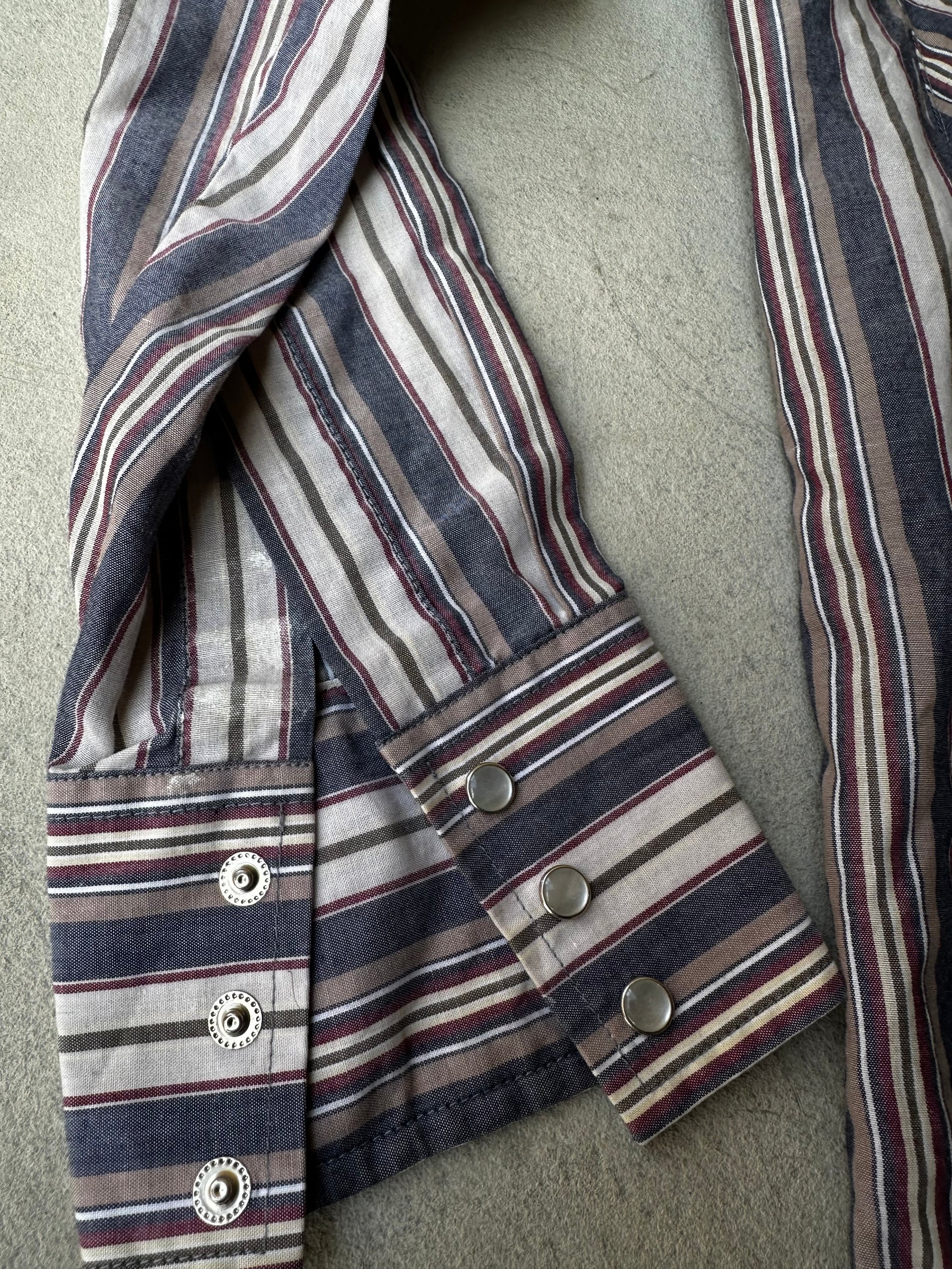 Long-sleeve vintage pearl snap western shirt with curved hem and rugged detailing