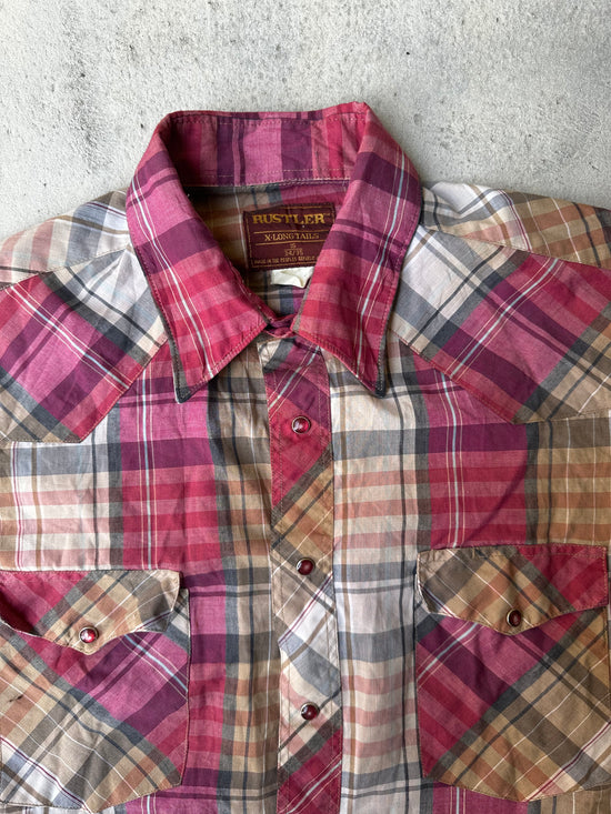 Close-up of pearl snap closure on vintage plaid cowboy shirt.