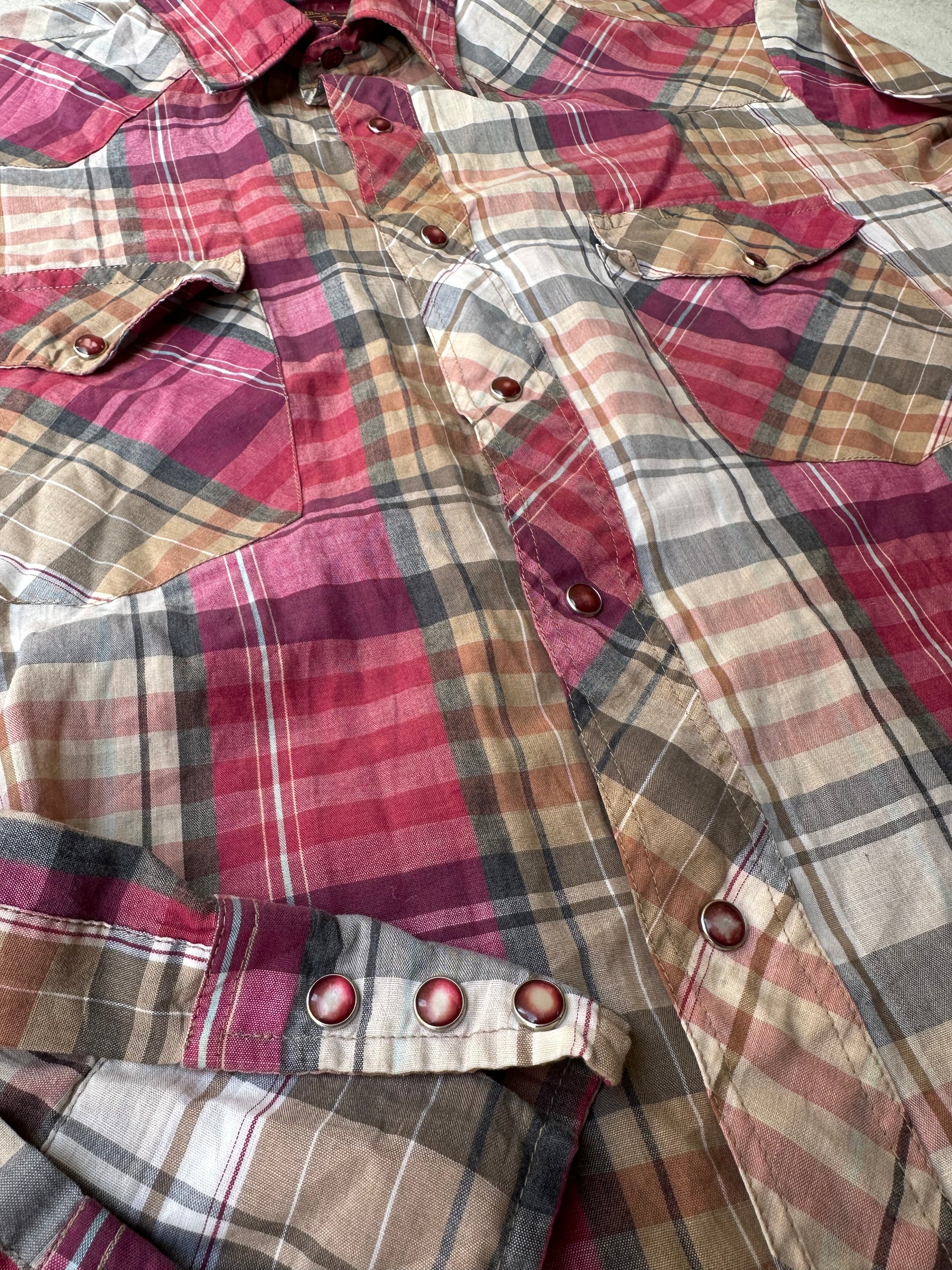 "Laid-flat vintage pearl snap western shirt with rugged, worn-in texture. closeup showing pearl snap buttons.