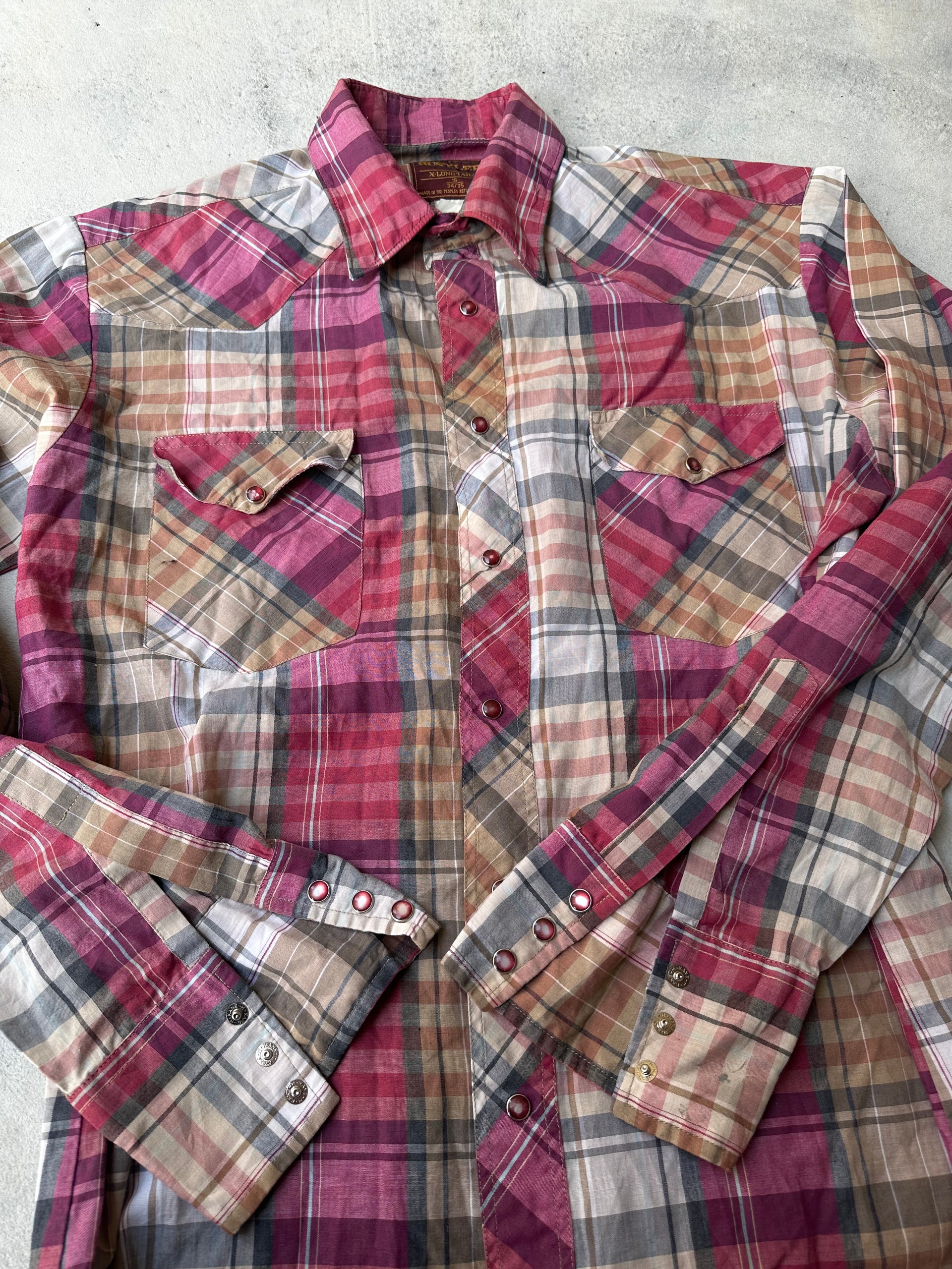 "Laid-flat vintage pearl snap western shirt with rugged, worn-in texture."