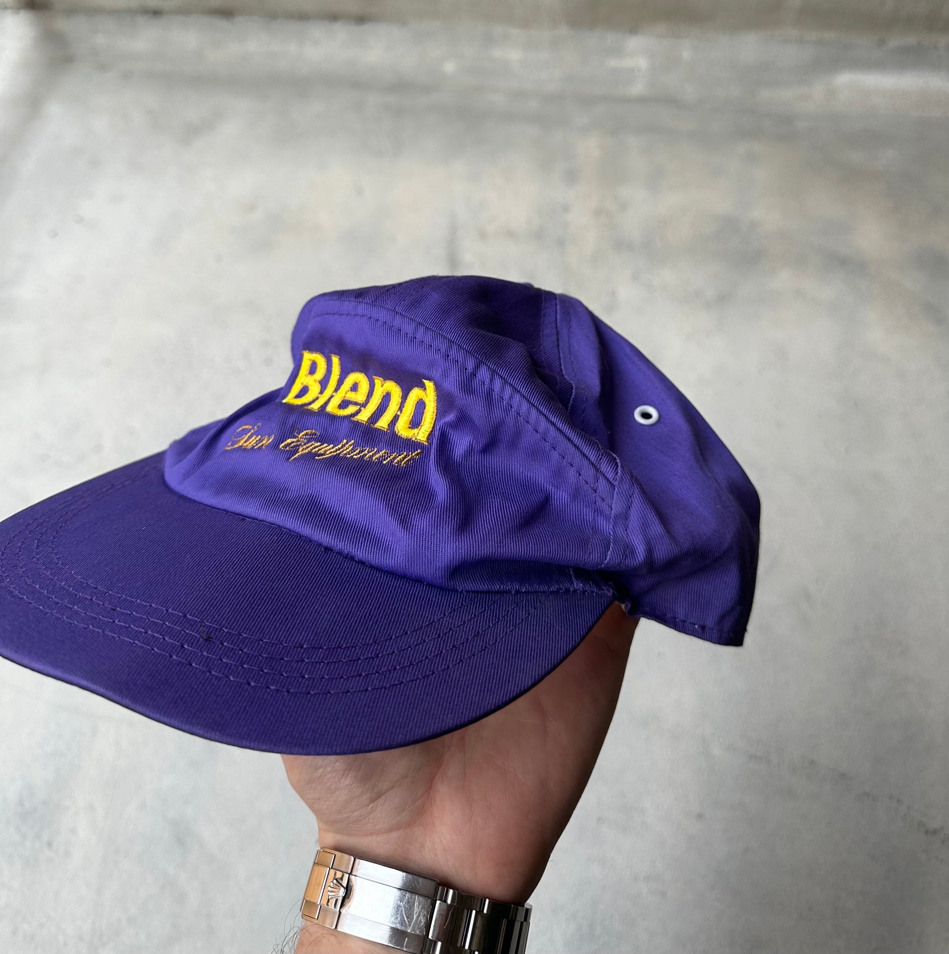Side view of adjustable purple Blend Sun Equipment cap against a neutral background.