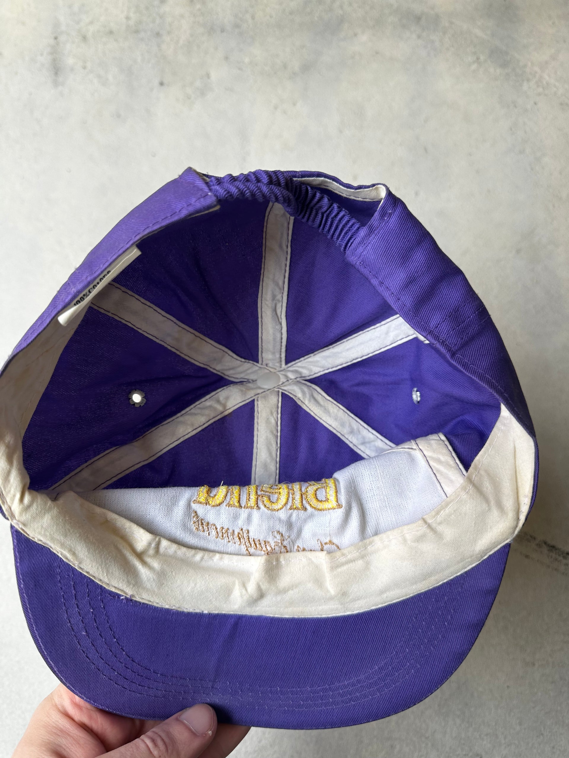 Hand holding vintage Blend Sun Equipment cap against neutral background and showing the inside of the cap.