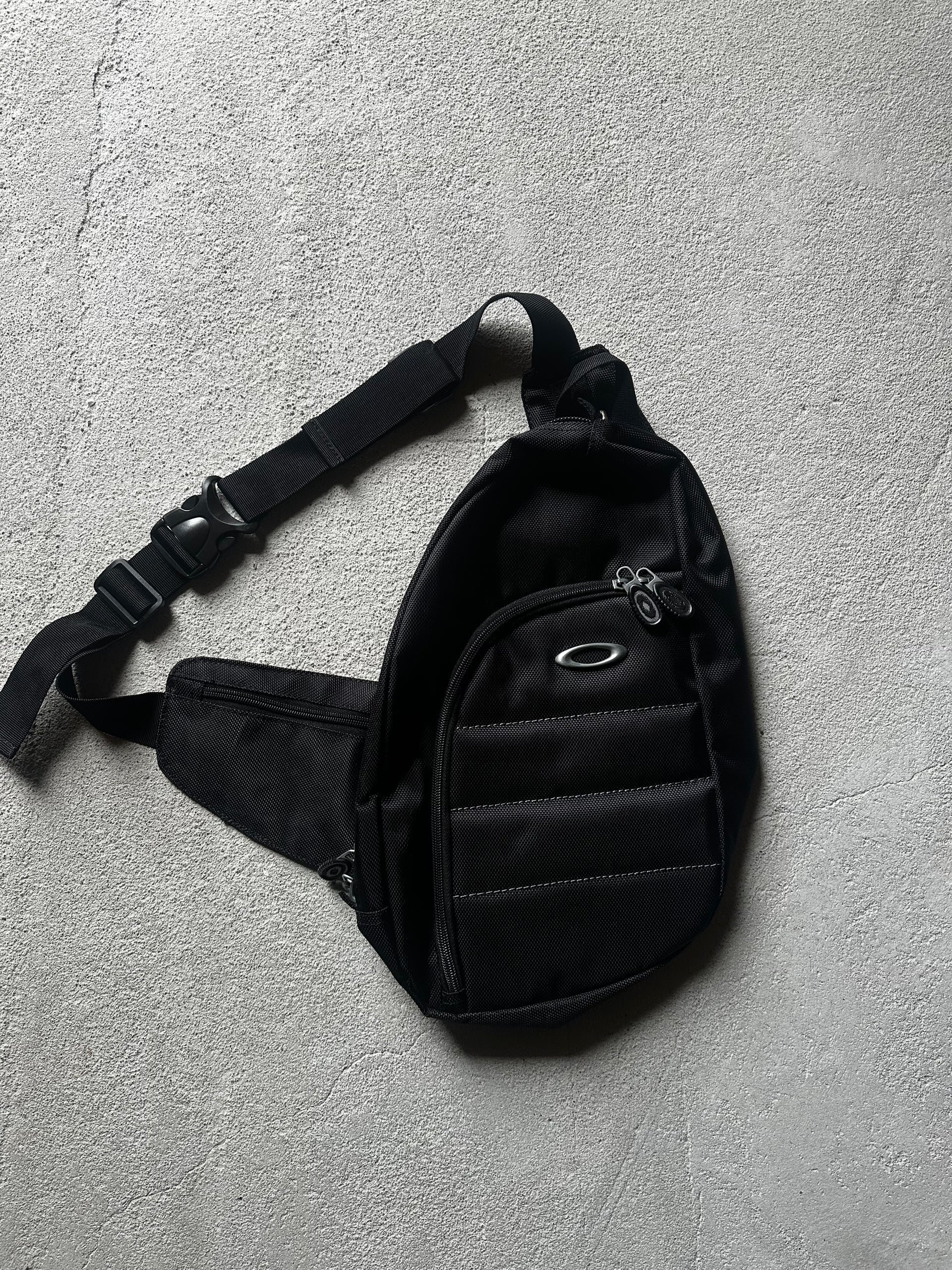 Retro crossbody-väska från Oakley med sportig form och teknisk design