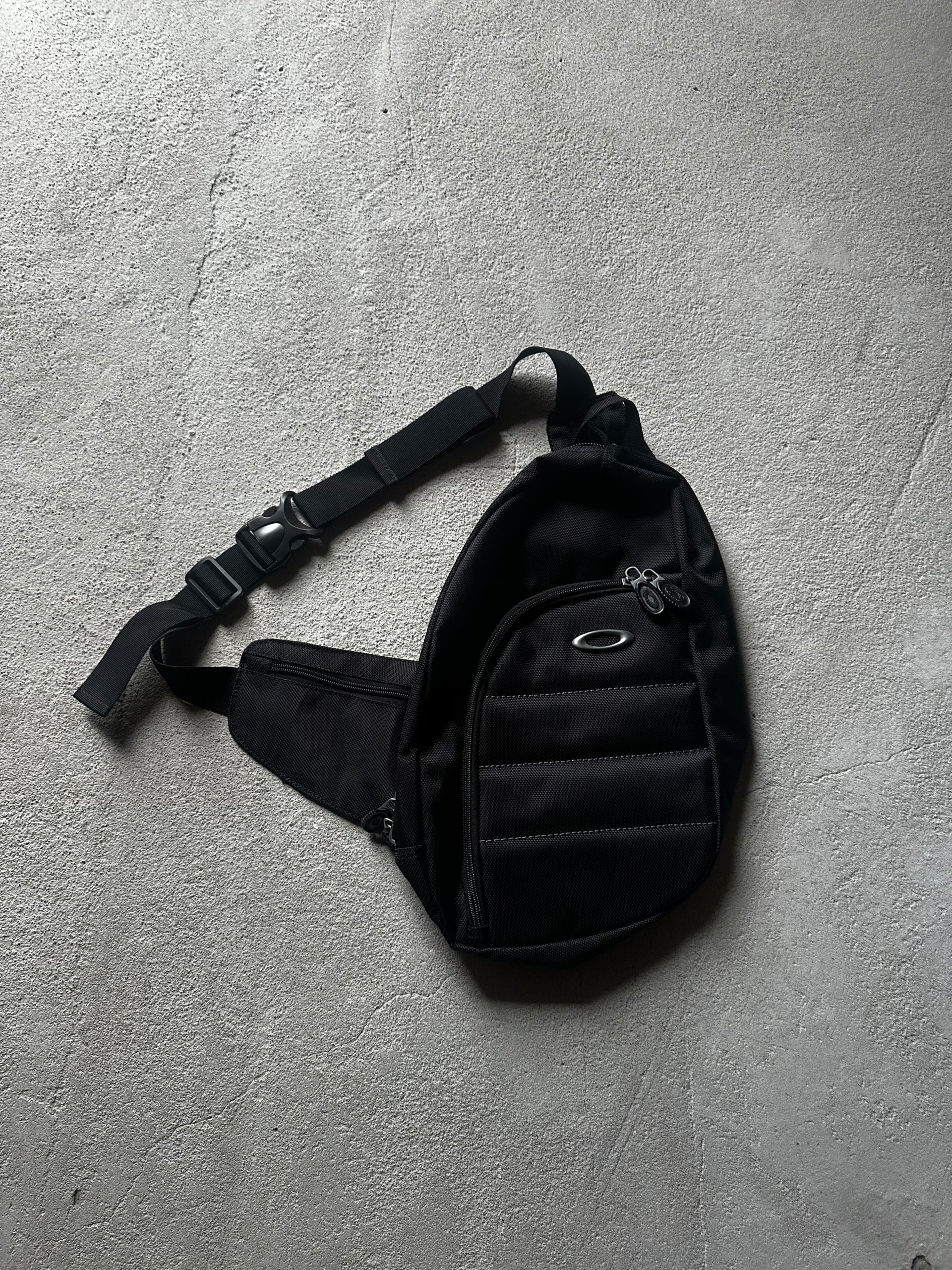 Vintage Oakley sling bag i svart med justerbart axelband och Oakley logga
