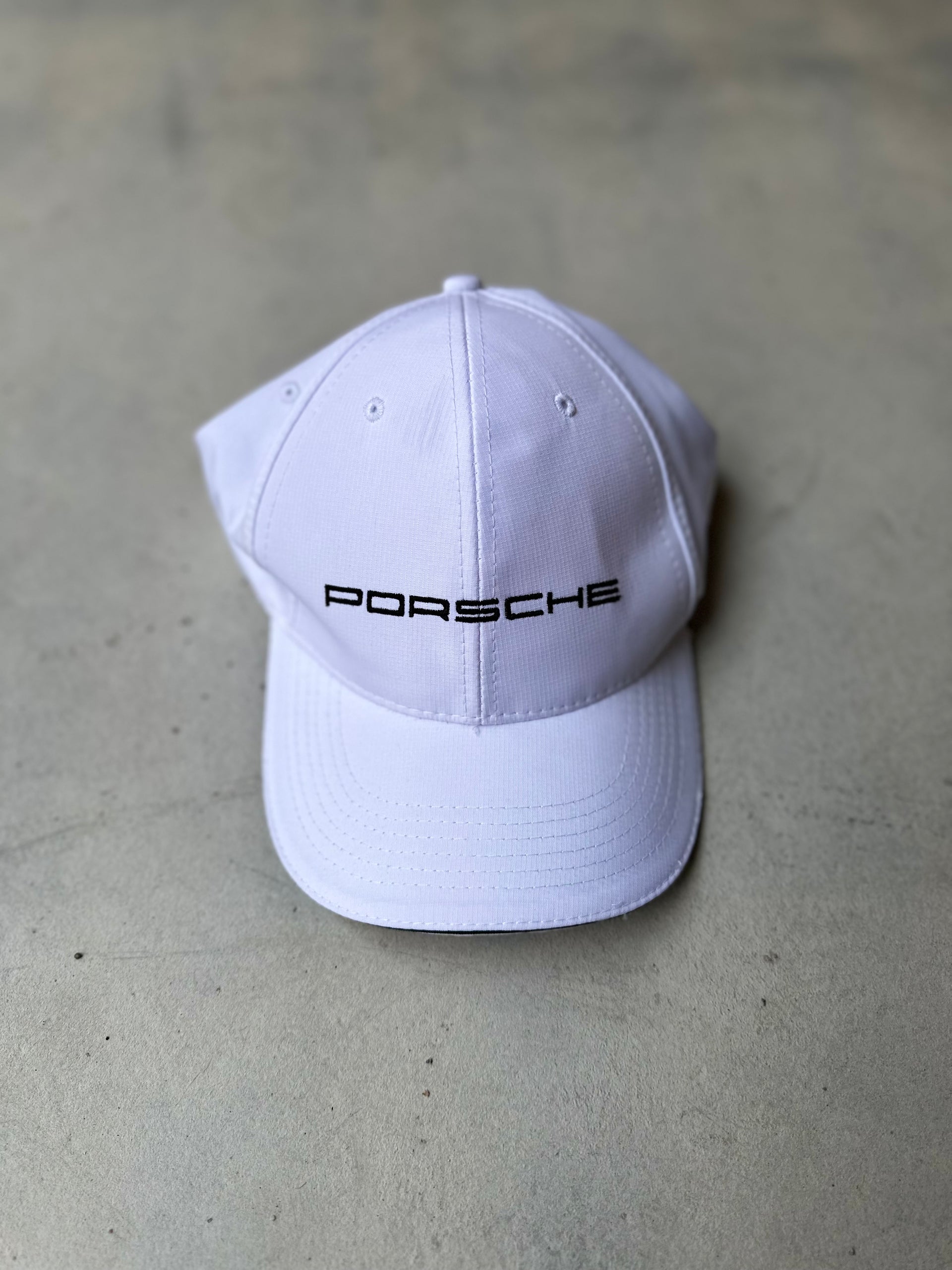 Classic Porsche hat with black stitching, featuring a sleek and sporty design.
