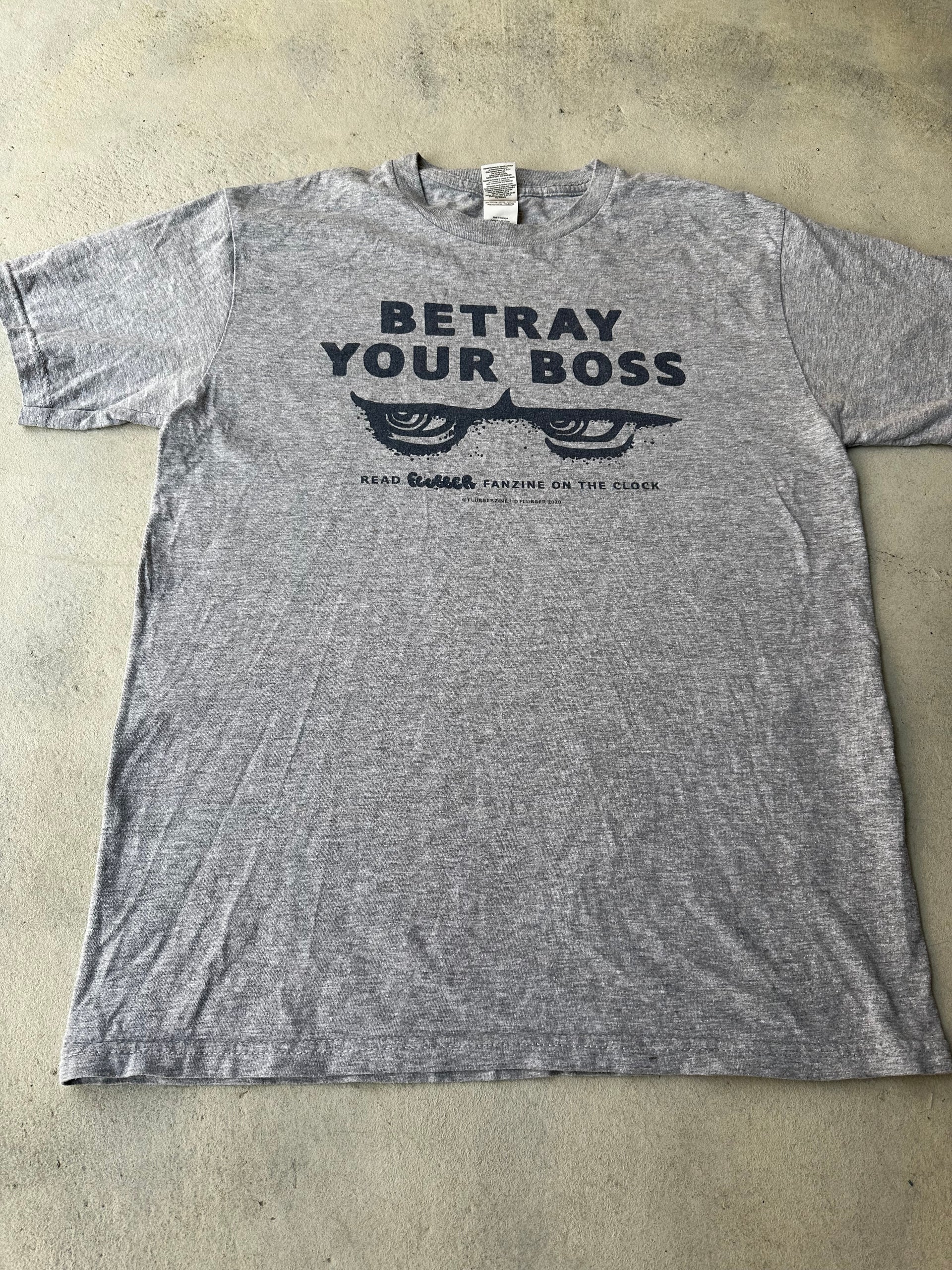 Laid-flat gray vintage graphic tee with subversive typography design.

