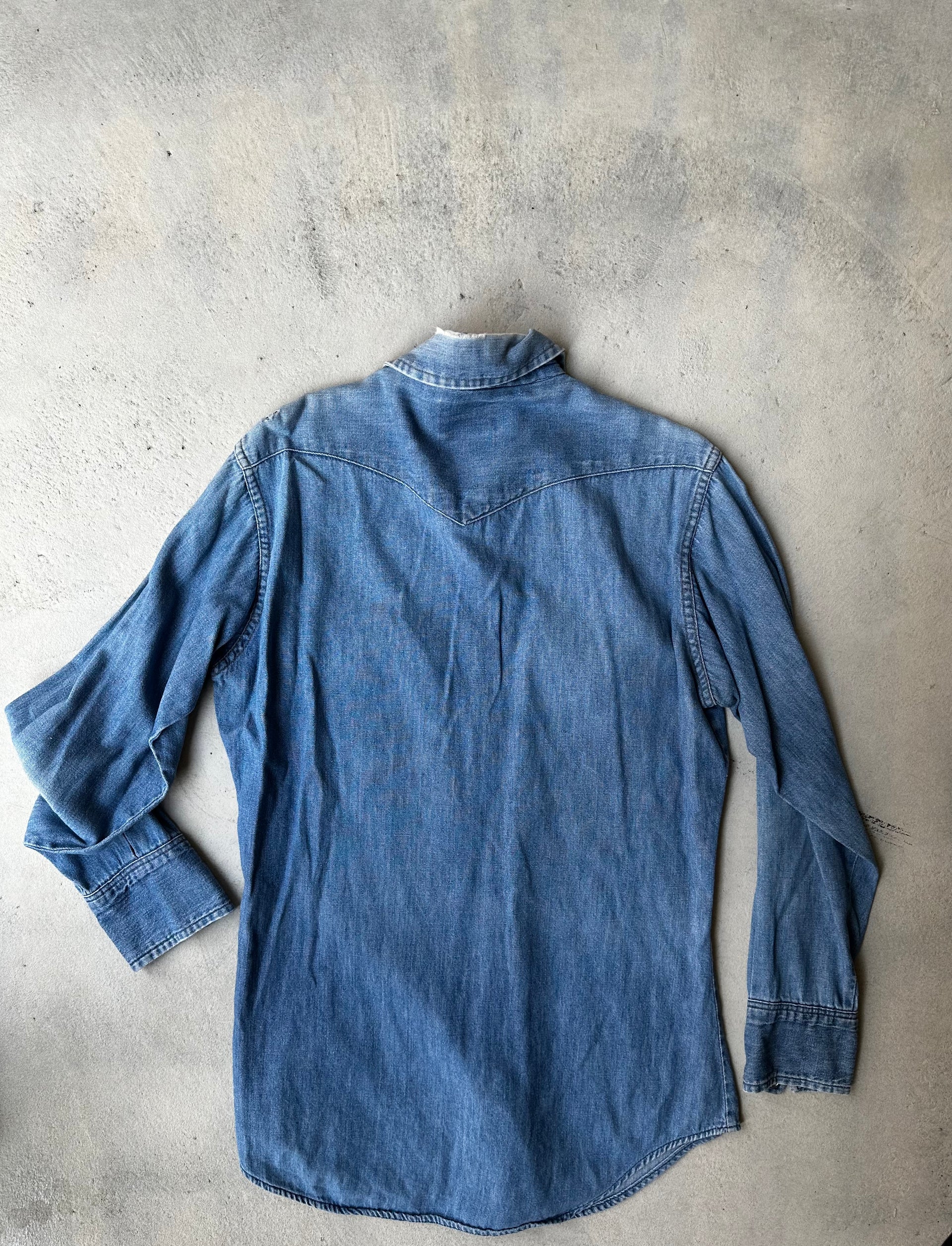 Laid-flat vintage Wrangler denim shirt, showing worn-in details and rugged character showing the back.