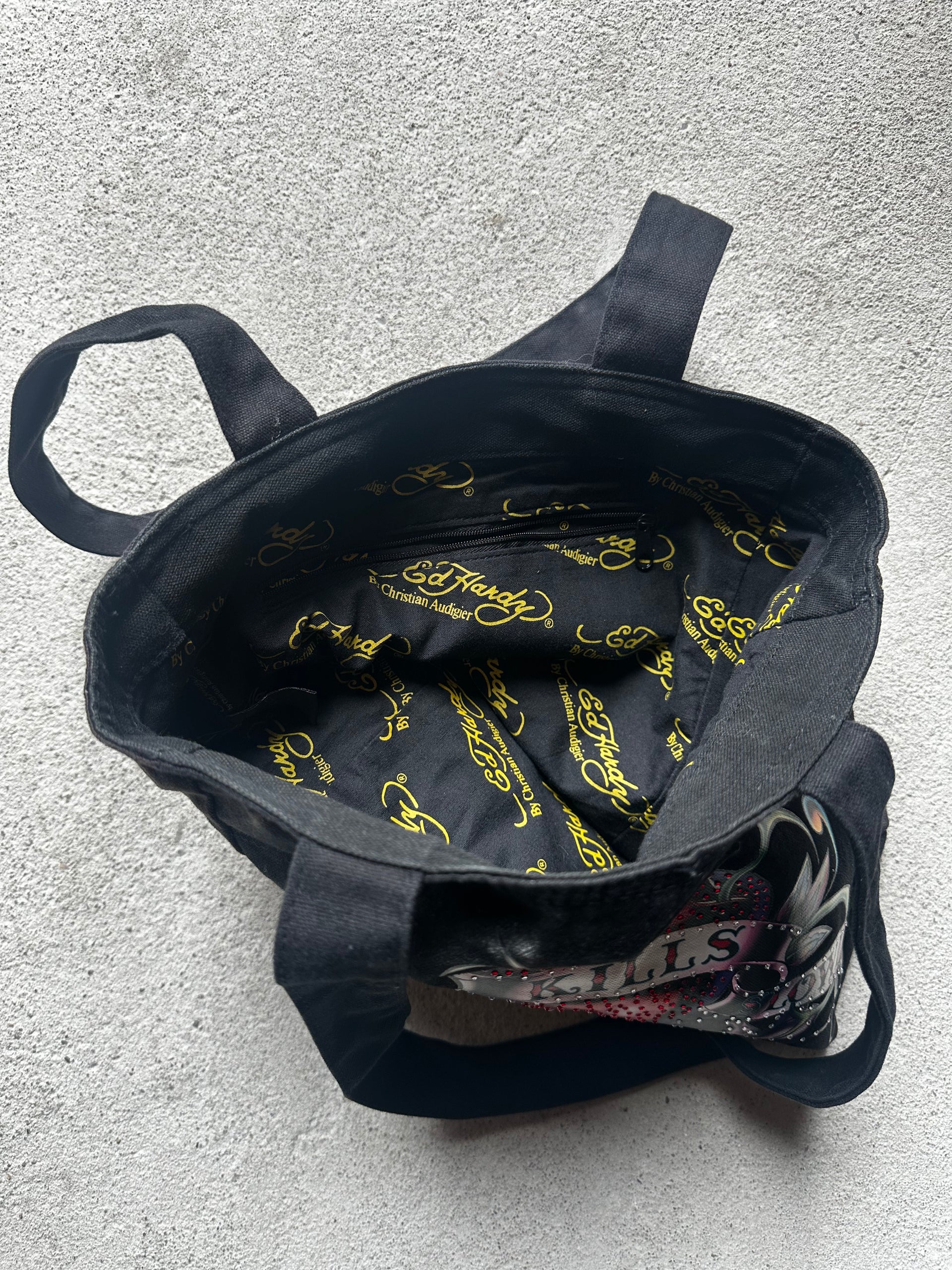 "Ed Hardy tote bag, reversible design with a bold tattoo-inspired graphic on one side and plain black on the other."

